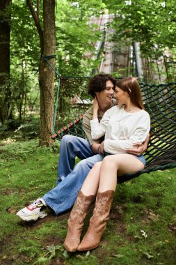 Sevgi dolu bir çift bir hamakta rahatlar, doğanın güzellikleri arasında gülücükler ve şefkat paylaşırlar..