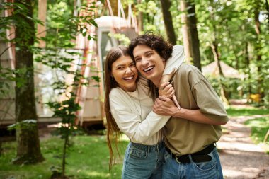 Çiftler gülüşlerini ve sevgilerini paylaşıyor. Huzurlu, ağaç dolu bir ortamda kucaklaşırken..