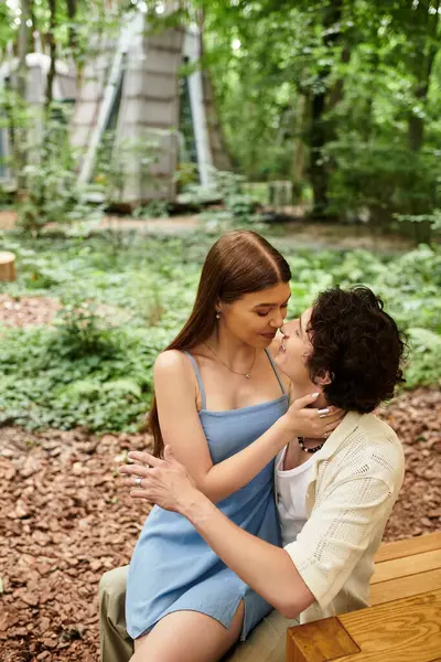 Sevgi dolu bir çift güzel bir parkta birlikte rahatlar, doğanın ortasında şefkatli bir öpücük paylaşırlar..