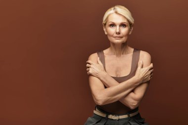 Son sınıf öğrencisi bir kadın kollarını kavuştururken kendine güvenir, güzel ve zarafet saçar..