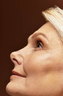 Güzel, son sınıf öğrencisi bir kadın zarif özelliklerini vurgularken düşünceli bir şekilde bakar..