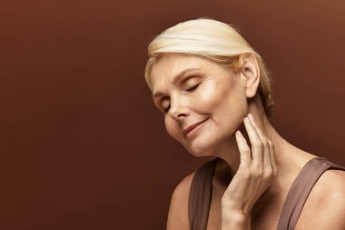 Kıdemli kadın kendinden emin, huzurlu bir ifadeyle ve nazik bir dokunuşla anın tadını çıkarıyor..