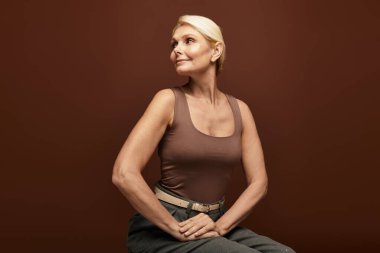 Güzel, son sınıf öğrencisi bir kadın zarif bir poz veriyor. Samimi bir stüdyo ortamında özgüven ve çekiciliğini sergiliyor..