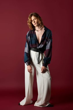 Yakışıklı genç adam şık kıyafetler sergiliyor, cesur ve renkli bir atmosfere güven yayıyor..