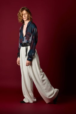 Genç, kadınsı bir adam moda tarzını canlı bir ortamda sergiliyor..