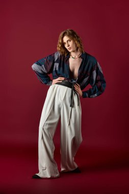 Şık genç adam canlı ve modern kıyafetlerle yaratıcı bir şekilde poz veriyor..