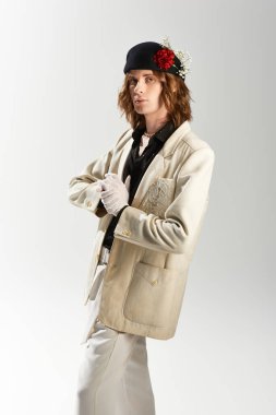 Şık bir ceketi ve şapkası olan genç bir adam kendine güven ve moda yeteneği yayar..