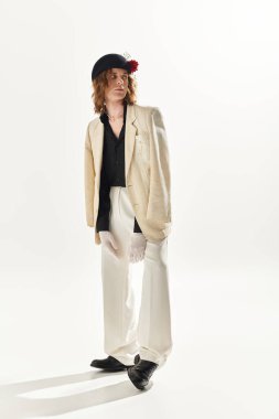 Yakışıklı genç bir adam çarpıcı bir kıyafet sergiliyor, zarafeti modern moda akımlarıyla harmanlıyor..