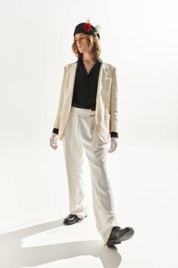 Göz alıcı genç bir adam kendine güvenen, zarif bir kıyafetle eşsiz tarzını sergiliyor..