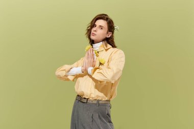 Çiçek kıyafetli yakışıklı genç bir adam zarif bir poz verir..