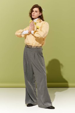 Genç bir adam benzersiz moda anlayışını modern bir mekanda çarpıcı bir kıyafetle sergiliyor..