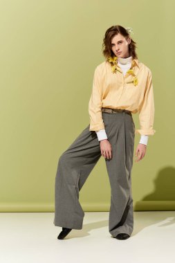 Tarz sahibi genç bir adam emsalsiz kadınsı bakışını yumuşak yeşil bir arka planda sergiliyor..