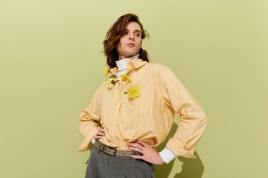 Genç adam, modern moda duyarlılığını ifade eden, kendine güvenen bir şekilde pastel renkte poz veriyor..