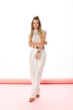 Güzel genç bir kadın şık bir kıyafet içinde modern moda eğilimlerini ön plana çıkarıyor..