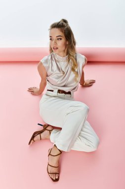 Şık giyimli kadın, canlı bir stüdyo ortamında kendine güvenen bir ifadeyle zarifçe poz veriyor.