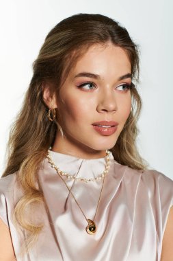 Genç bir kadın zarif bir şekilde poz veriyor, göz kamaştırıcı mücevherlerini parlak bir zemine vurguluyor..