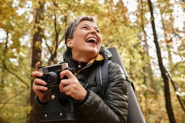 Son sınıf öğrencisi kadın orman yürüyüşünde fotoğraf makinesiyle anılarını yakalar..