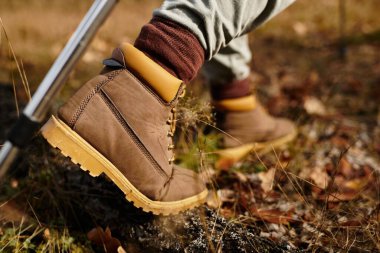 Sağlam yürüyüş botları içinde ayaklar doğa güzelliğiyle çevrili güzel bir orman patikasında geziniyor..