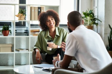 İki genç profesyonel, iyi aydınlatılmış bir stüdyoda röportaj yapıyorlar..