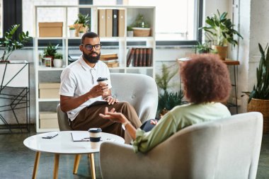 Röportaj sırasında parlak bir stüdyoda sohbet eden iki genç profesyonel..