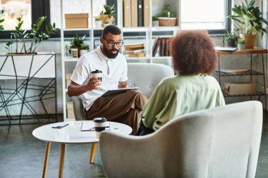 İki genç profesyonel, parlak bir stüdyo içinde mülakata katılıyor..