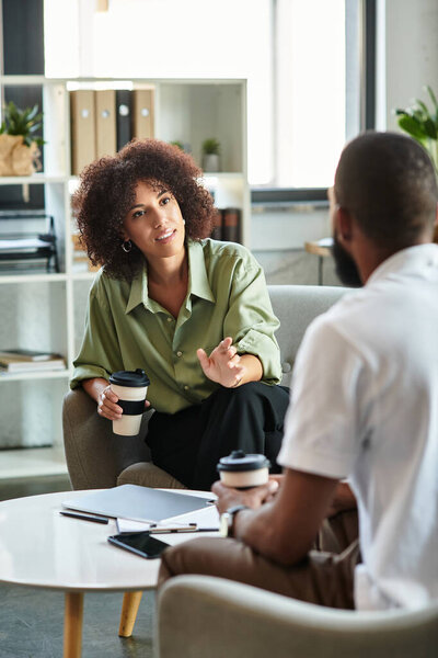 A young woman engages in discussion during a interview with a confident man.