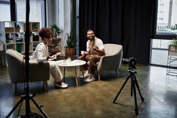 Женщина и мужчина участвуют в энергичном интервью в гладкой студии.