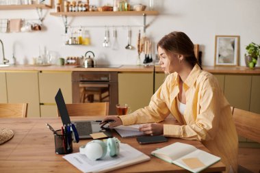 Güzel genç kadın sıcak ve davetkar bir mekanla çevrili evdeki işine odaklanmış.
