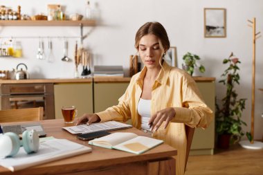 Genç bir kadının çay yudumlarken düşünceli bir işe giriştiği parlak ve davetkar bir yer..