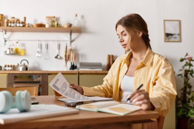 Çalışmalarıyla meşgul olan genç bir kadın, notlar alırken evinin huzurunun tadını çıkarıyor..