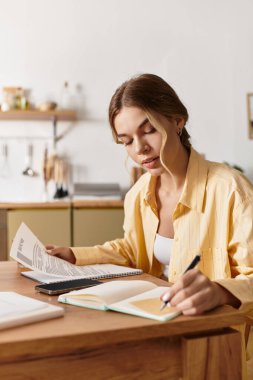 Çalışmalarıyla meşgul olan genç bir kadın, ev ofisine notlar ve eleştiriler yazıyor..