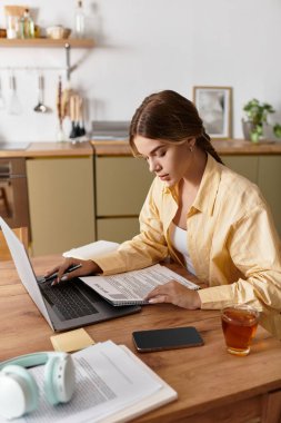 Kendini işine adamış bir kadın evde, sıcaklık ve yaratıcılıkla çevrili bir şekilde ders çalışıyor..