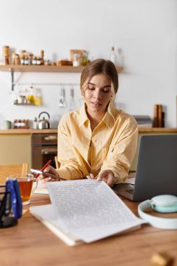 Genç kadın, şık çalışma alanındaki projelerini yazmaya ve düzenlemeye odaklanıyor.