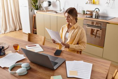 Genç bir kadın masasında huzur içinde oturuyor, rahat evindeki belgeleri gözden geçiriyor..