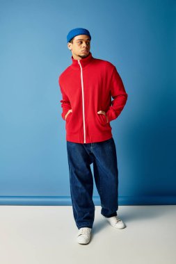 Modayı takip eden Afrikalı genç bir Amerikalı parlak kırmızı bir elbise ve mavi bir bere giyiyor..