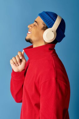 Bereli genç bir adam müzik dinlerken gülümsüyor..