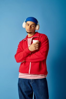 Kendine güvenen genç bir Afrikalı Amerikalı kahvesini yudumluyor, şık modasını sergiliyor..