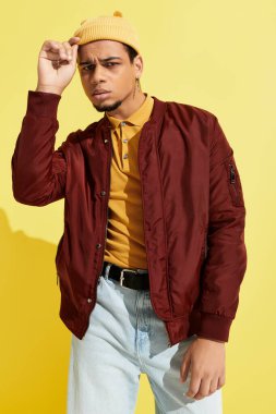 Genç bir Afrikalı Amerikalı, modaya uygun bombacı ceketiyle poz veriyor..