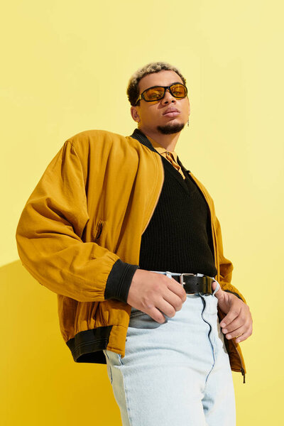 A young African American man showcases a trendy bomber jacket against a vibrant yellow backdrop.