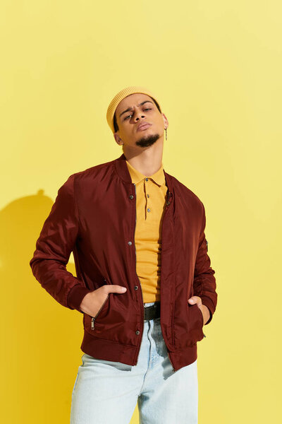 A young african american man confidently poses in a trendy bomber jacket, embracing modern fashion.