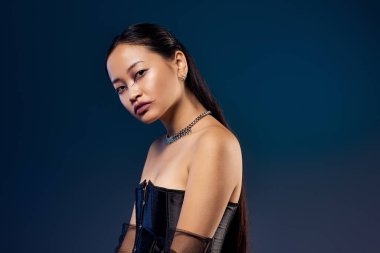 Genç bir kadın büyüleyici makyaj malzemeleri sergiliyor ve şık siyah bir korse, somut bir gizem..