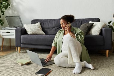 Bir kadın evinde telefonla konuşurken işini rahatça dengeliyor..