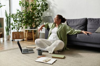 Uzaktan kumandalı bir Afrikalı Amerikalı kadın, bitkilerin arasında rahatça çalışıyor..