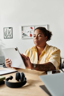 Parlak, sıradan dairesinde uzaktan kumandalı bir kadın tabletine odaklanmış..