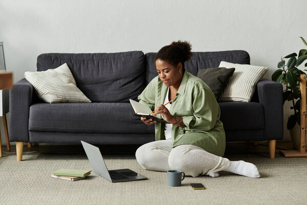 An African American woman engages in freelance work while sitting comfortably in her apartment.