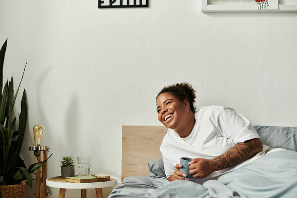 An African American woman enjoys a beautiful morning in her modern bedroom, smiling joyfully.