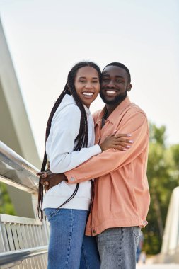 Sevgi dolu çift, dışarıda romantik bir gezinti yapar. Sıcak güneş ışığında kucaklaşır ve gülümser..