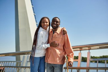 Sevgi dolu bir çift, güneşli güzellikleri kucaklayarak, manzaralı bir yürüyüş yolunda mutlu bir şekilde dolaşır..