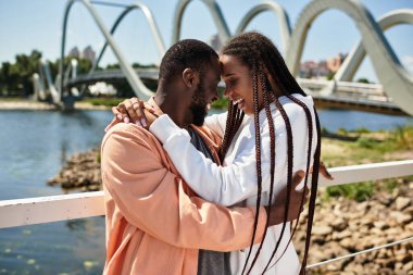Birbirini seven çiftler, eşsiz bir köprüyle kıyı şeridi boyunca yürürken birbirlerini kucaklarlar..