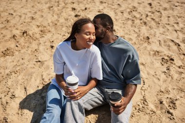 Kumsalda el ele yürür, güler ve sıcak içecekleri paylaşırız..